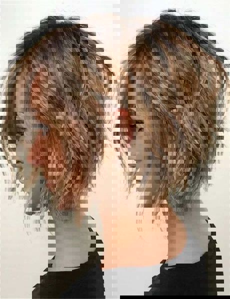 Roztrzepany krótki bob w ciepłym odcieniu miodowym z pasemkami w kolorze popielatego blondu. Roztrzepany krótki bob w ciepłym odcieniu miodowym z pasemkami w kolorze popielatego blondu.